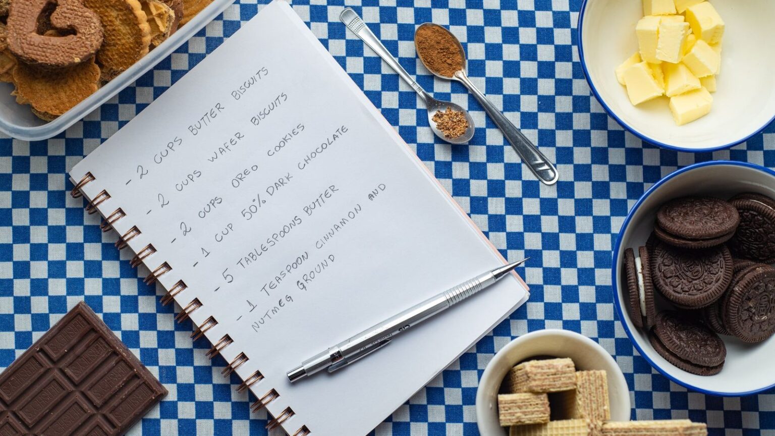 Familienrezepte aufschreiben, bevor sie verschwinden Handgeschriebenes Rezeptbuch neben Backzutaten