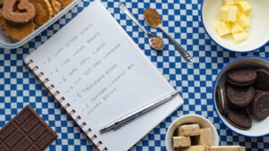 Familienrezepte aufschreiben, bevor sie verschwinden Handgeschriebenes Rezeptbuch neben Backzutaten